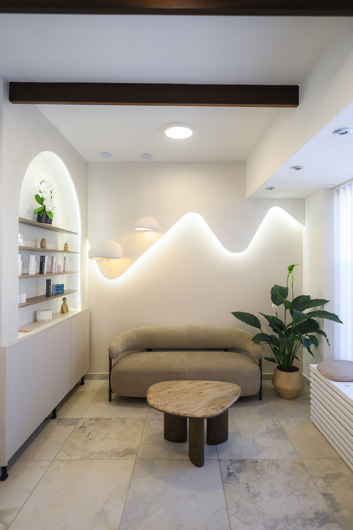 Wartebereich mit Sofa und Lichtwelle an der Wand