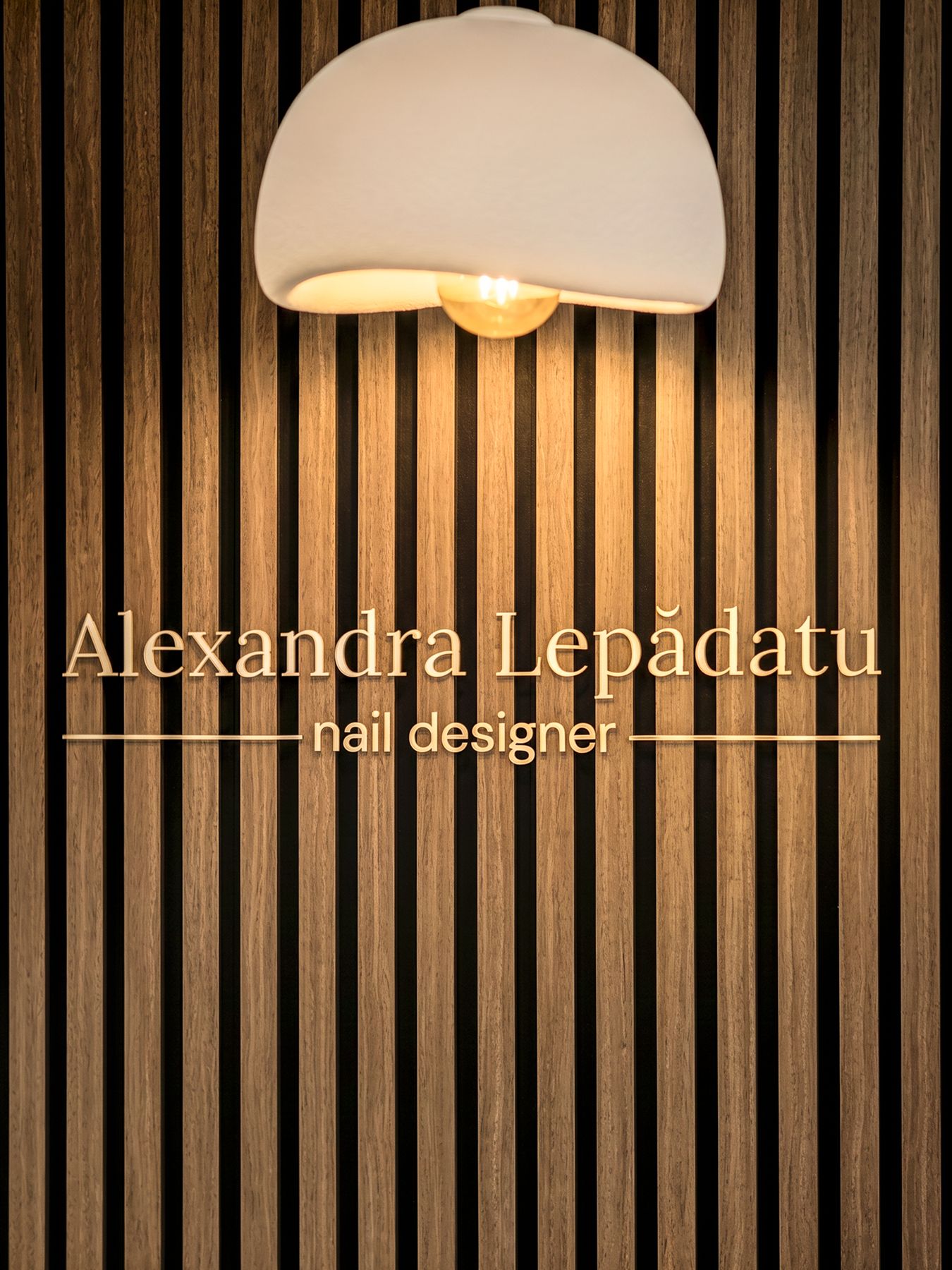 Holzlamellenwand mit Schriftzug Alexandra Lepădatu nail designer